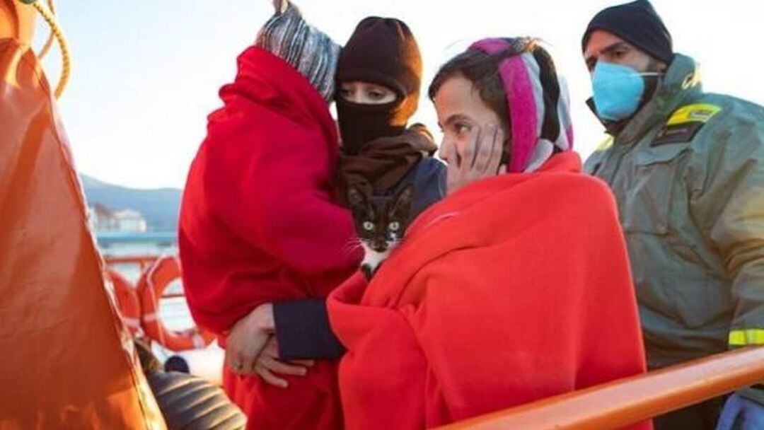 La pequeña, con el felino, antes de bajar de la patera.