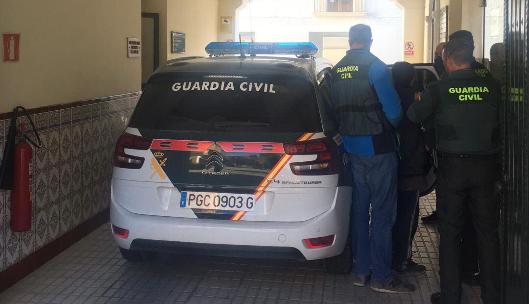 Agentes de la Guardia Civil introducen al detenido en el coche.