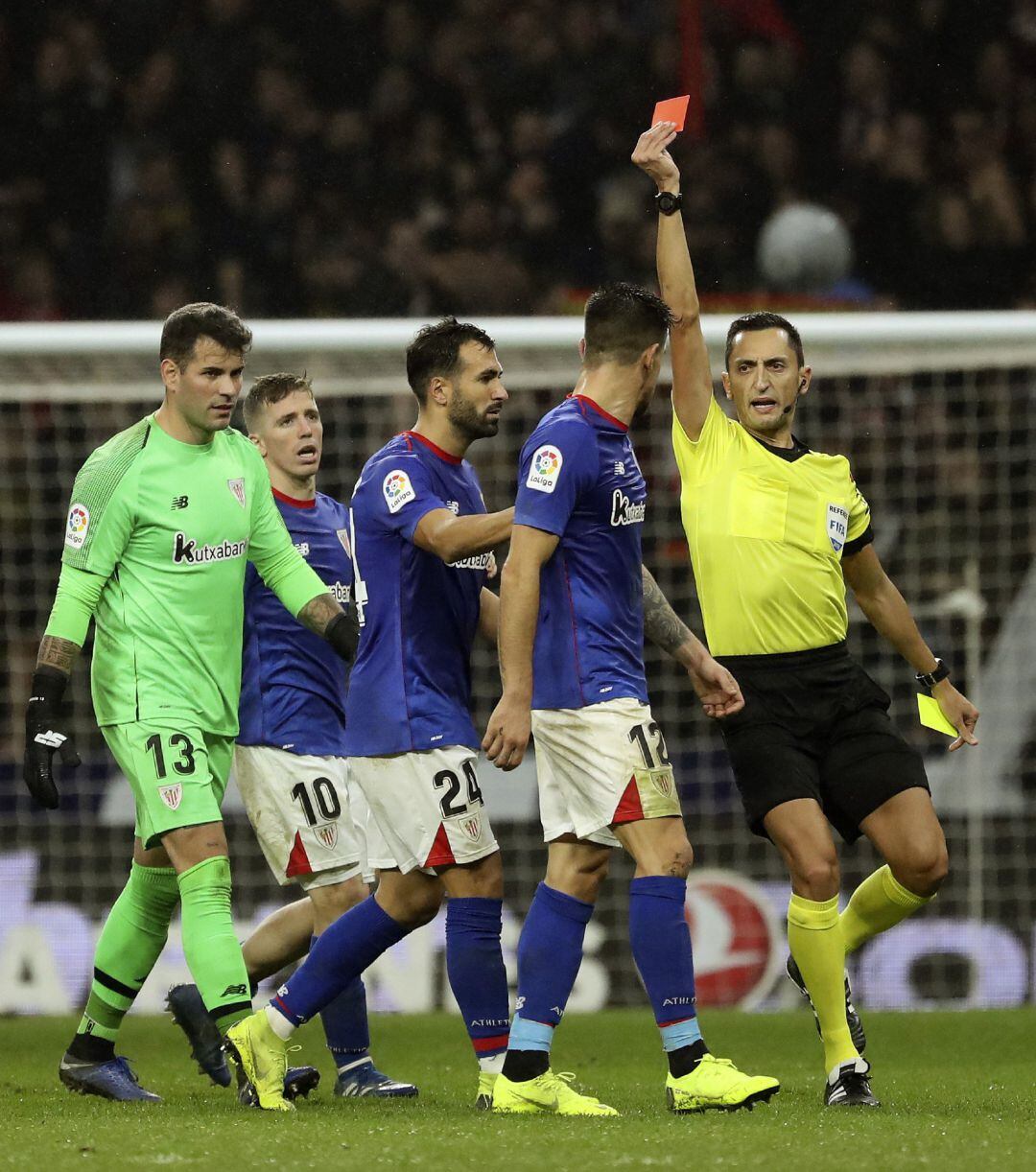 El colegiado Sánchez Martínez muestra tarjeta roja al defensa del Athletic, Yuri Berchiche (2d), a la finalización del encuentro correspondiente a la jornada 12 de primera división que han disputado frente al Atlético de Madrid en el estadio Wanda Metropo