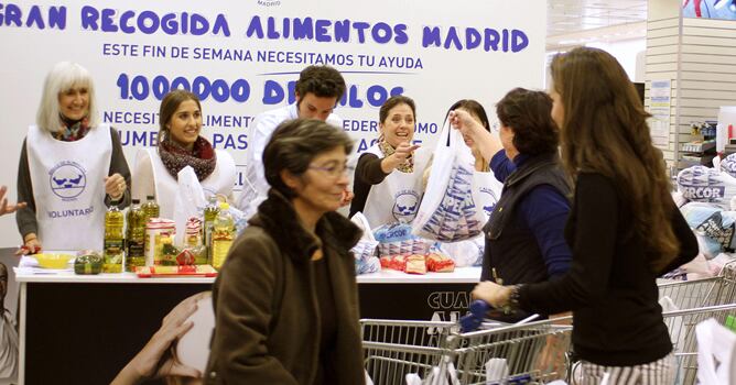 Fotografía facilitada por la 'Gran Recogida', de varios voluntarios participando en esta campaña del Banco de Alimentos, en un supermercado de Madrid