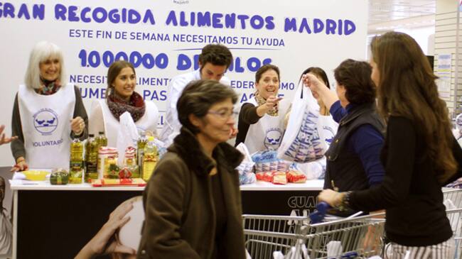 Fotografía facilitada por la 'Gran Recogida', de varios voluntarios participando en esta campaña del Banco de Alimentos, en un supermercado de Madrid