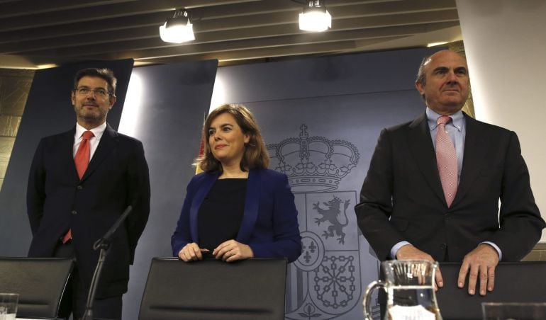 GRA197 MADRID 27/2/2015 La vicepresidenta del Gobierno, Soraya Sáenz de Santamaría, y los ministros de Justicia Rafael Catalá (dch) y de Economía Luis de Guindosal inicio de la rueda de prensa del Consejo de Ministros. EFE/SERGIO BARRENECHEA