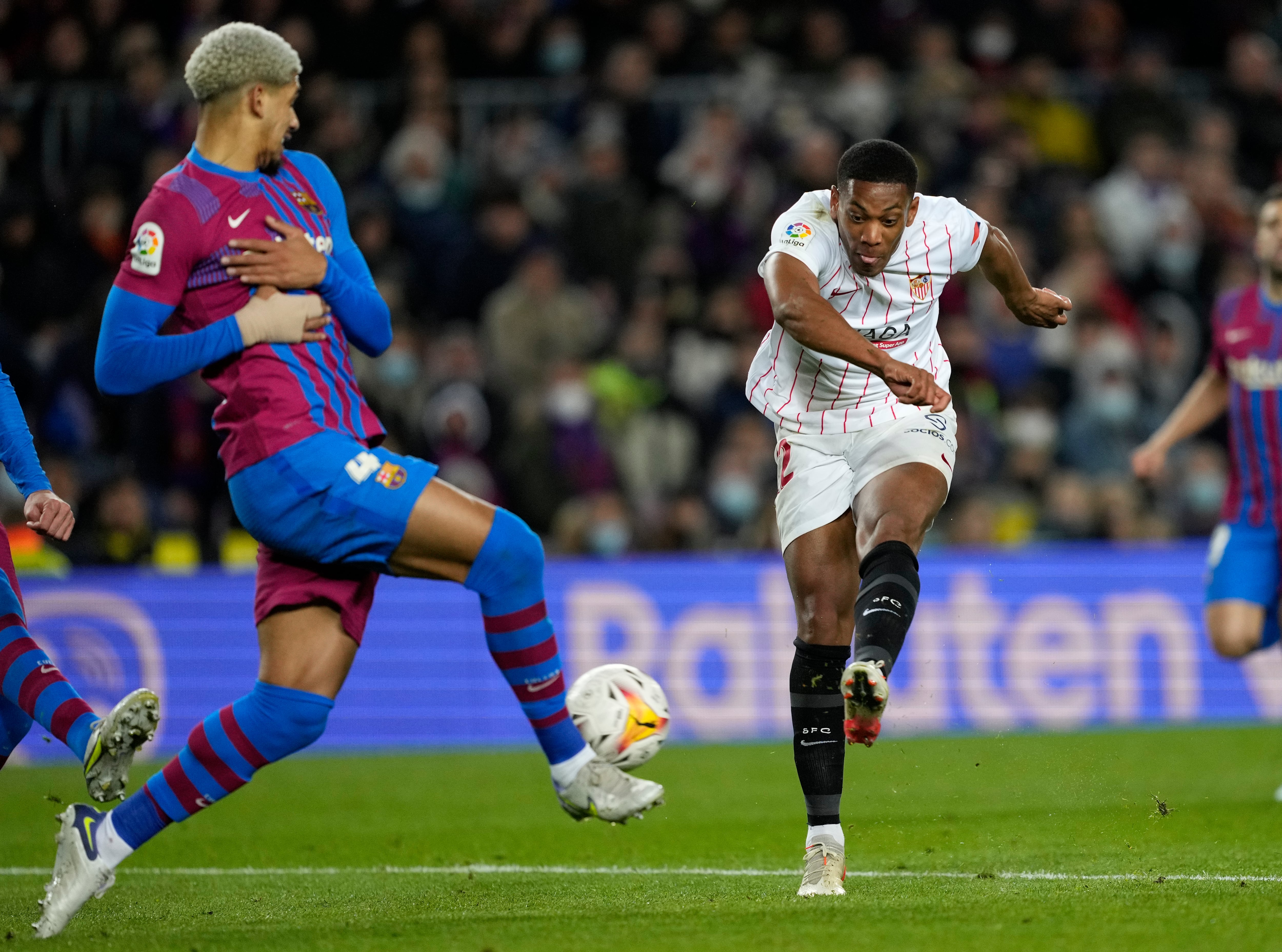 BARCELONA, 03/04/2022.- El delantero francés del Sevilla Anthony Martial (d) dispara junto al uruguayo Ronald Araújo, del FC Barcelona, durante el encuentro de la jornada 30 de Liga en Primera División que FC Barcelona y Sevilla FC juegan hoy domingo en el Camp Nou, en Barcelona. EFE/Alejandro García