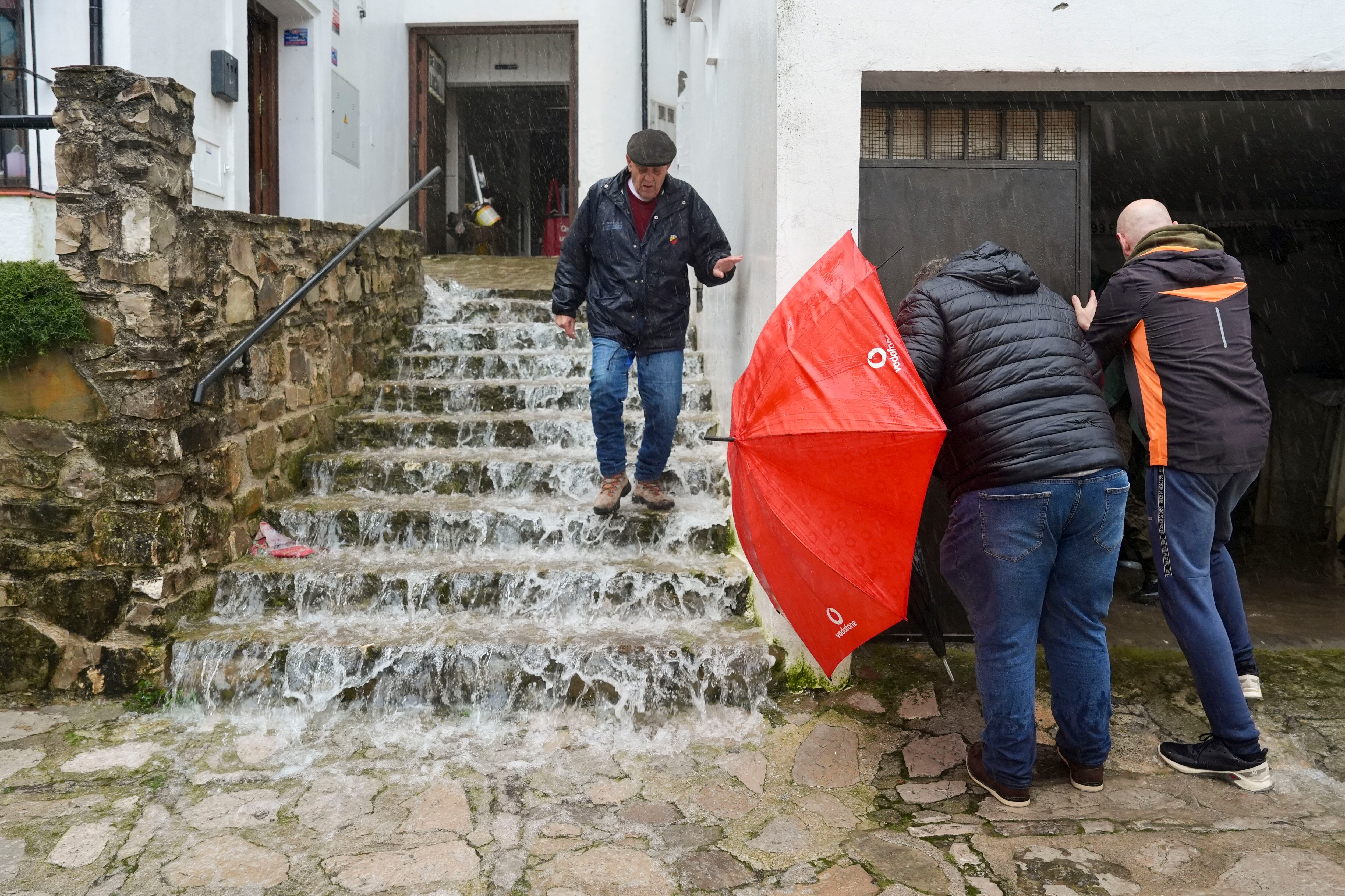 Un vecino de Grazalema (Cádiz) baja las escaleras inundadas debido a las intensas lluvias que se registran este miércoles en la localidad gaditana