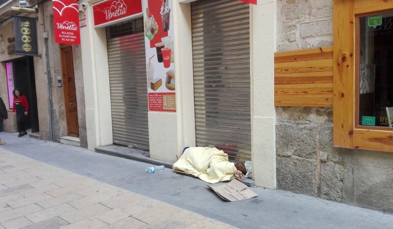 Una persona duerme en la calle Mayor de Alicante