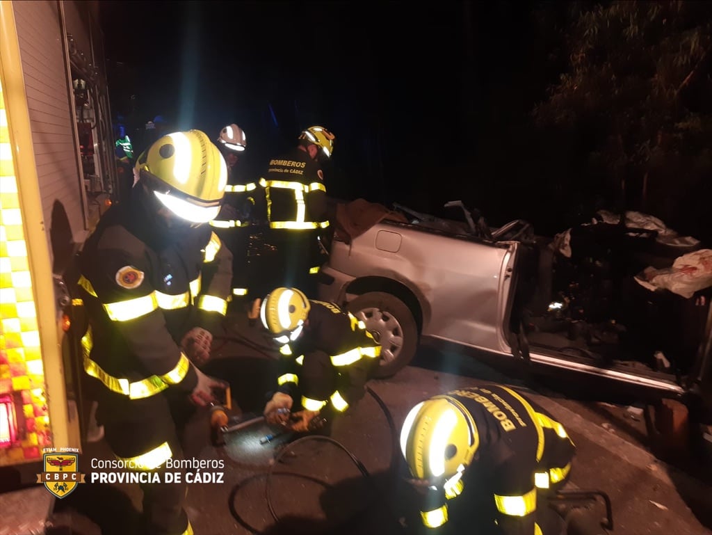 Los bomberos durante su intervención en el accidente registrado en la A-384