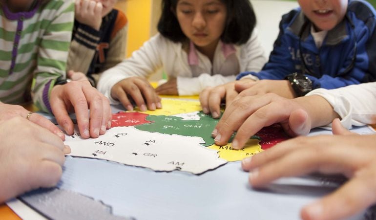 Alumnos trabajando con la plantilla en relieve de un mapa de España