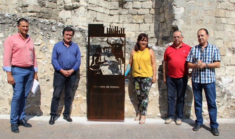 Parte de la corporación municipal y el anterior concejal de Festejos muestran el totem de los encierros de Interés Turístico Internacional situado en la plaza de los Coches