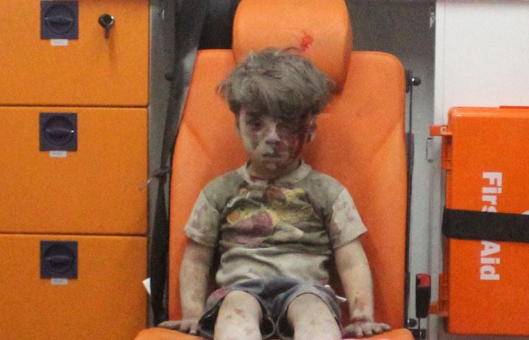 Five-year-old Omran Daqneesh, with bloodied face, sits inside an ambulance after he was rescued following an airstrike in the rebel-held al-Qaterji neighbourhood of Aleppo, Syria August 17, 2016. Picture taken August 17, 2016. REUTERS Mahmoud Rslan  