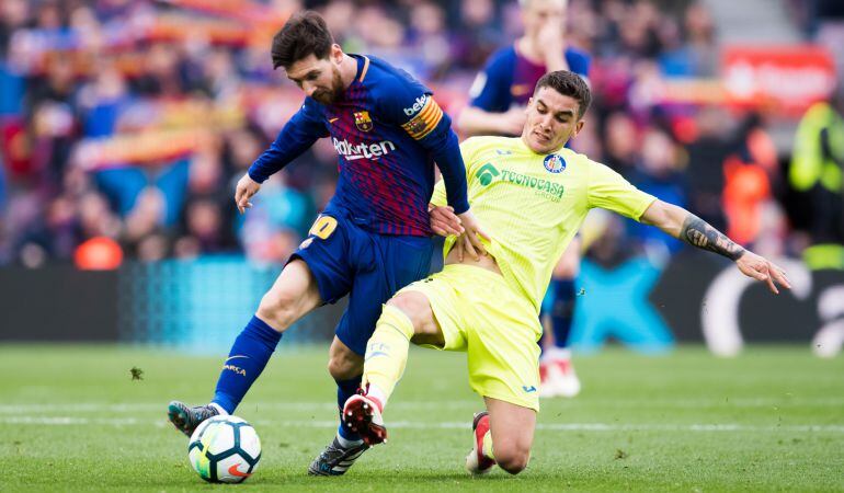 Arambarri (d) intenta arrebatar el balón al blaugrana Messi durante el partido ante el Barça en el Camp Nou.