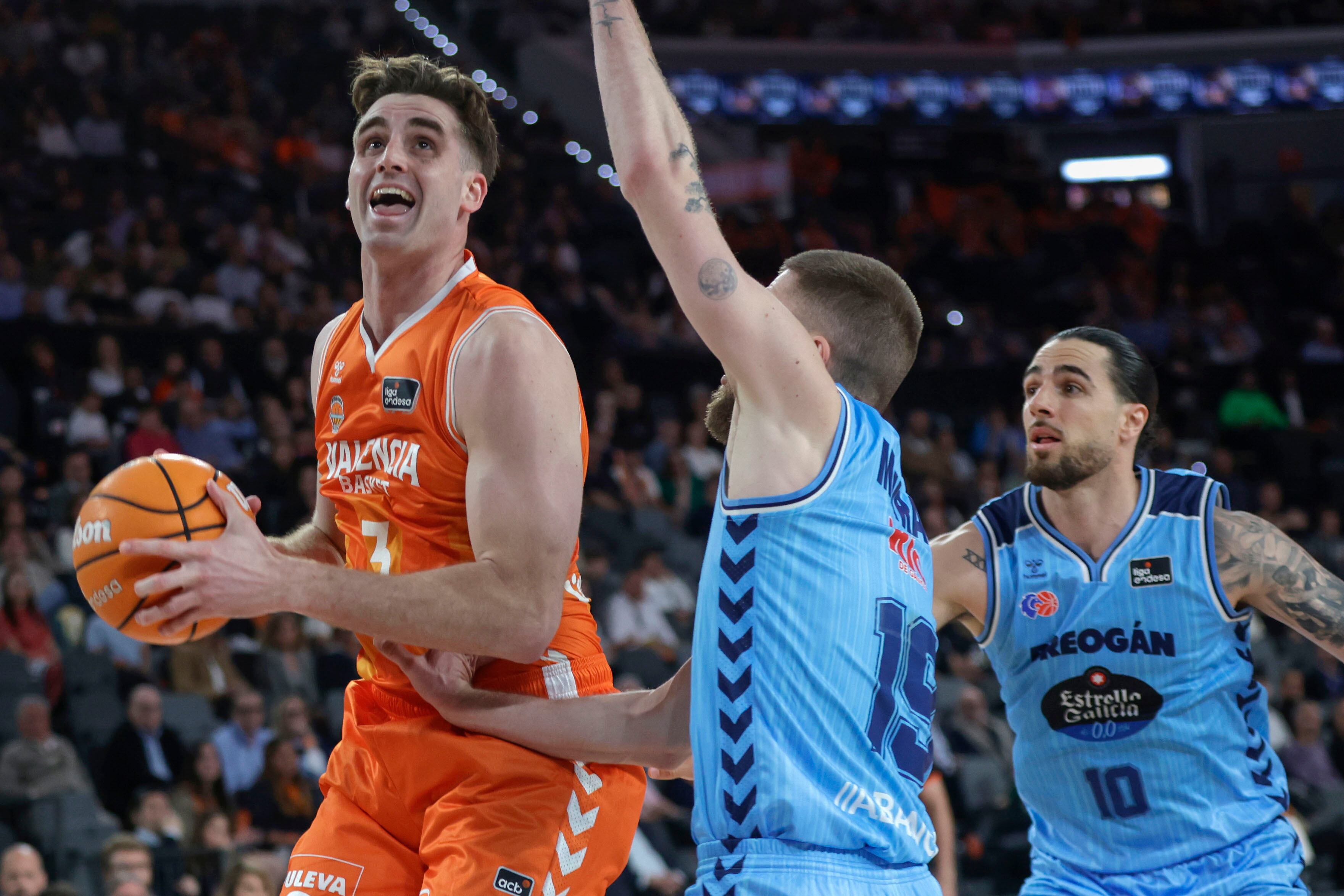 VALENCIA, 05/04/2026. El jugador de Rio Breogan, Dominik Mavra (c), defiende al jugador de Valencia Basket, Nate Reuters, durante el encuentro correspondiente a la fase regular de la Liga Endesa que disputan este Domingo Valencia Basket y Rio Breogan en el Roig Arena de Valencia. EFE/Miguel Ángel Polo.