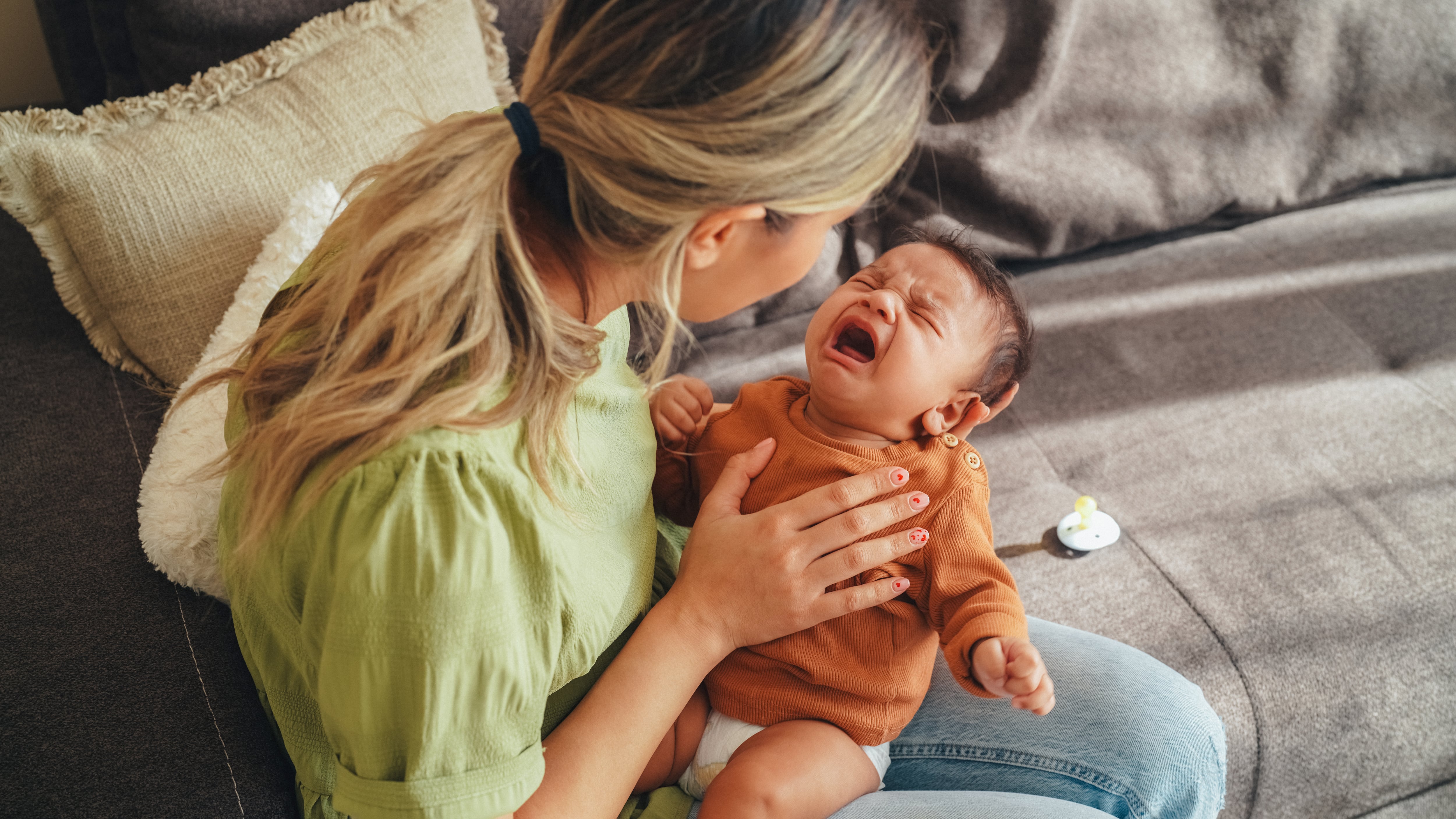 Mother holding in hands a crying baby