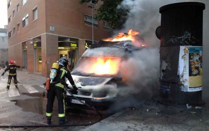 Els bombers treballan per apagar el foc a la unitat mòbil de TV3 cremada pels encaputxats