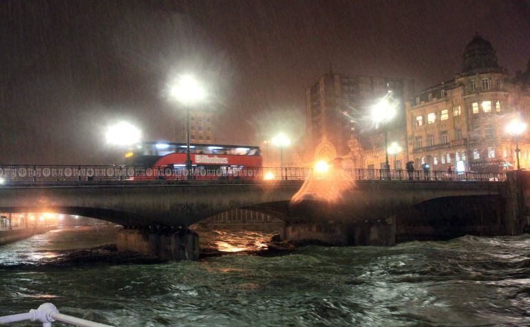 GRA532. BILBAO, 30/01/2015.- El ayuntamiento de Bilbao espera que la ría del Nervión-Ibaizabal se pueda desbordar a su paso por la capital vizcaína hacia las 23.30 horas, por lo que ha pedido retirar los vehículos aparcados en las zonas cercanas al cauce y llevarlos a las partes altas de la ciudad. En la foto, aspecto que presenta esta noche la ría a su paso por la capital bilbaína. EFE/Luis Tejido