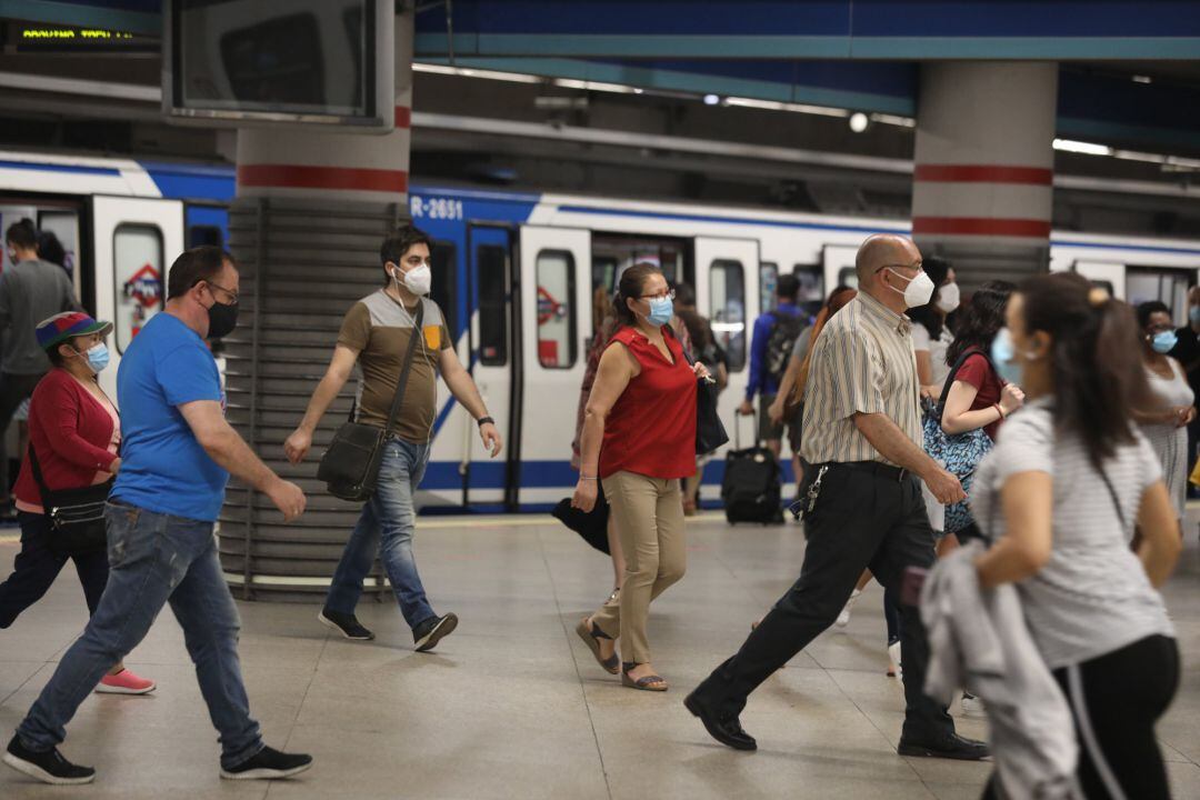 Pasajeros con mascarilla salen de un vagón en la estación de Metro de Atocha, en Madrid (España)