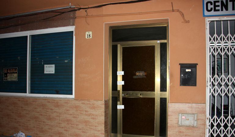 Entrada precintada a l'edifici on residia la víctima a Cunit