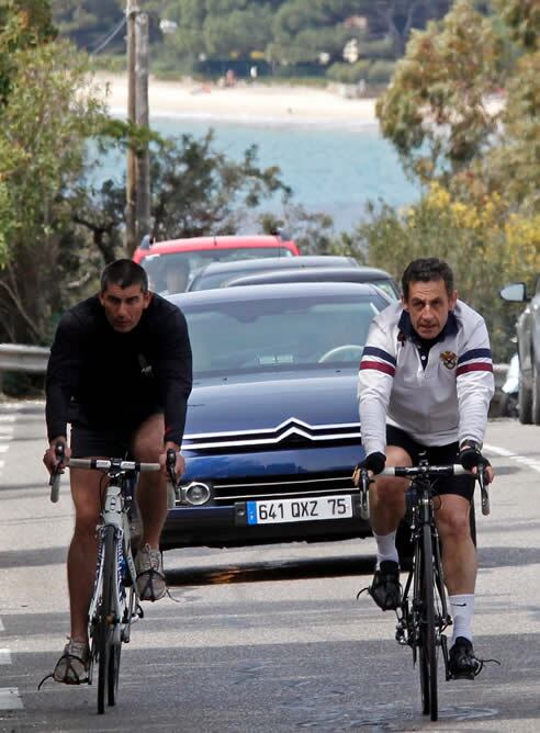 El presidente y candidato conservador francés a la reelección, Nicolas Sarkozy, monta en bici junto a un guardaespaldas cerca de la casa de su mujer, Carla Bruni, en el sur de Francia