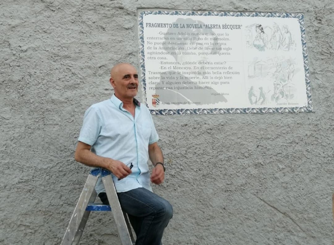 Miguel Mena, subido a una escalera, junto a la placa que recuerda un fragmento de su novela &#039;Alerta Bécquer&#039;