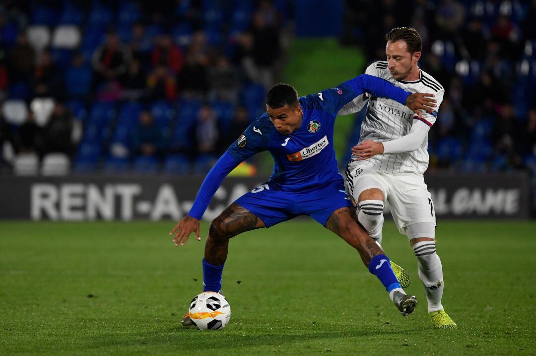 El centrocampista del Getafe CF Kenedy (i) compite con el del FC Basel Luca Zuffi durante el partido del jueves en el Coliseum