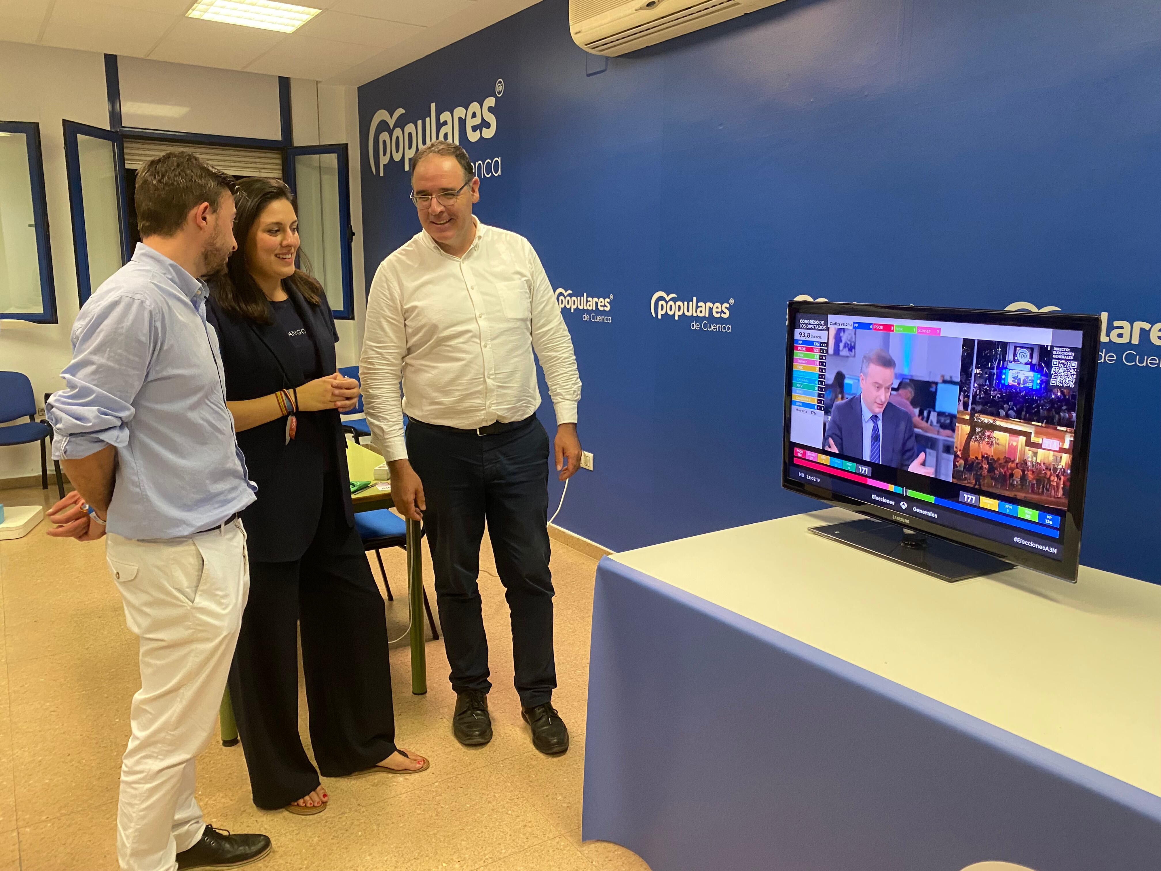 Daniel Pérez Osma y Beatriz Jiménez, diputados electos, junto al presidente del PP de Cuenca, Benjamín Prieto, siguiendo el escrutinio de las elecciones generales del 23J en la sede del partido en Cuenca.