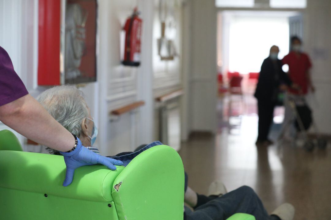 Archivo - Una trabajadora de una residencia traslada a un usuario.