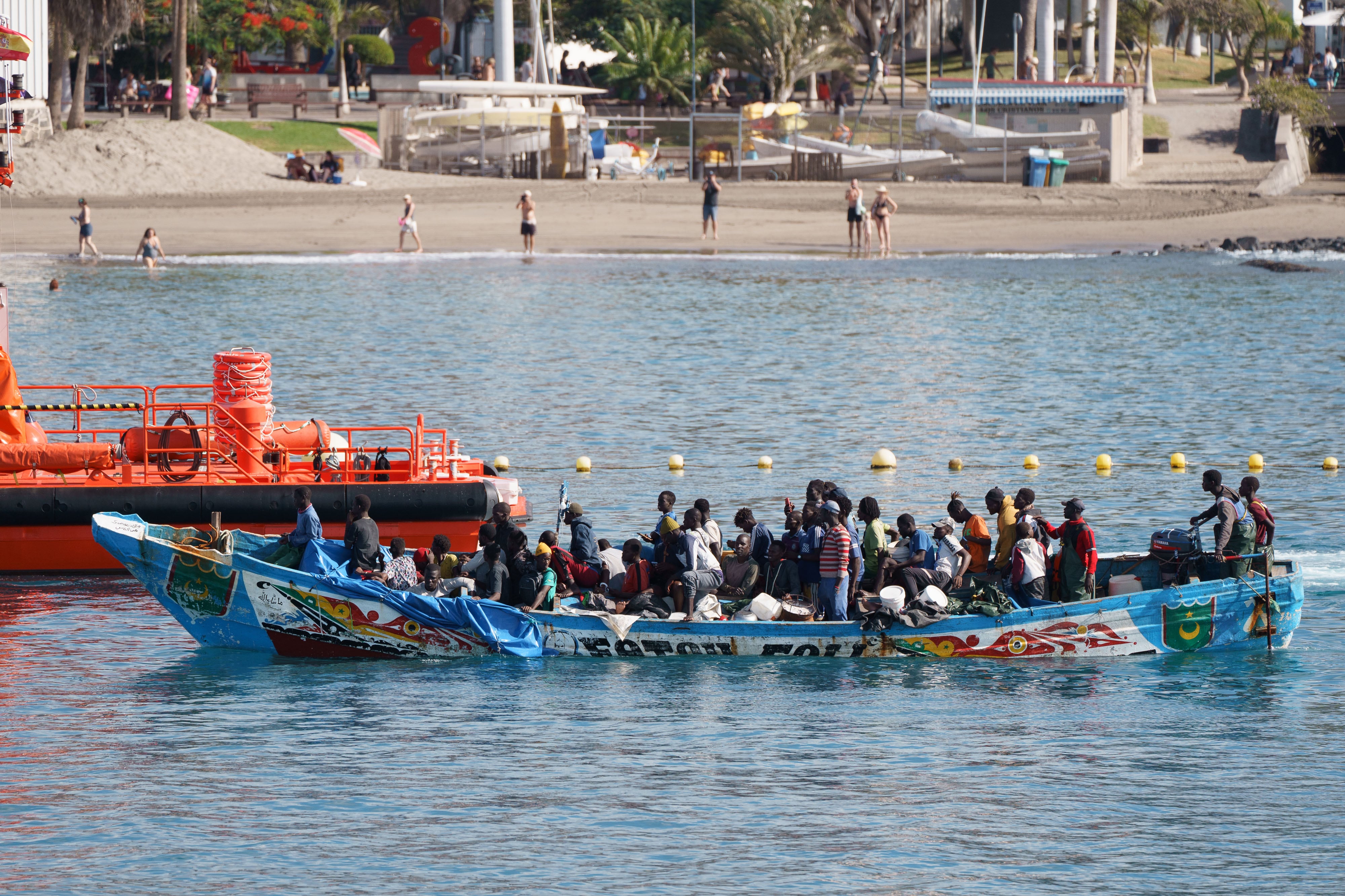 Un cayuco arribó este domingo al puerto de Los Cristianos en Tenerife remolcado por una embarcación de Salvamar