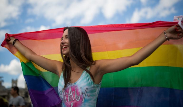 Una joven luce la bandera del Orgullo Gay.