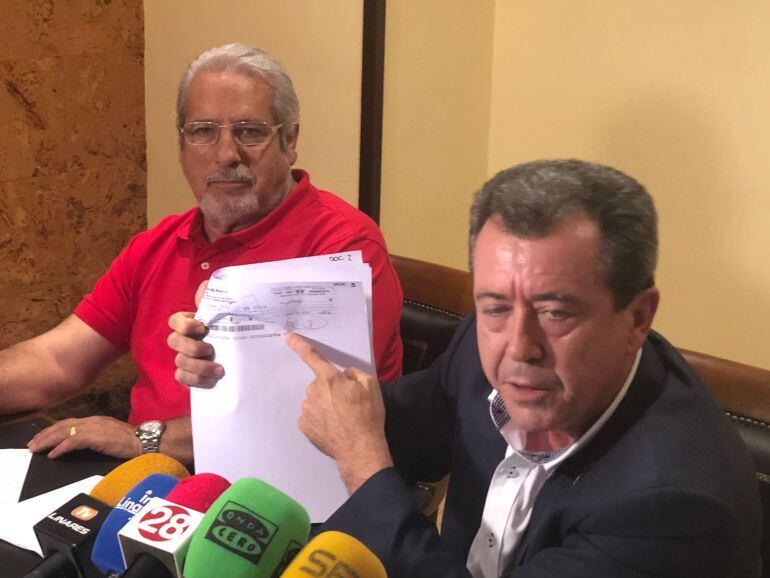 Juan Fernández y Juan Sánchez muestran cheques firmados mancomunalmente. 