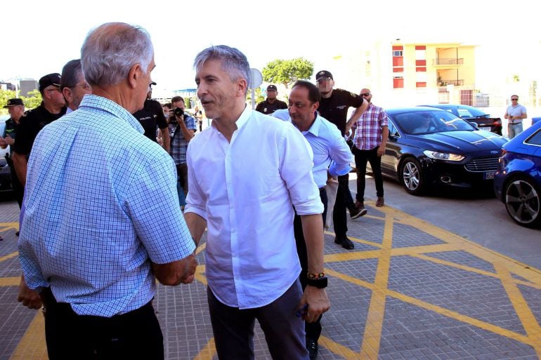 El ministro del Interior, Fernando Grande Marlaska, saluda al capitán marítimo de Algeciras, Julio Berzosa, esta tarde en Algeciras (Cádiz), donde ha acudido para supervisar el dispositivo de salvamento y acogida de los cientos de inmigrantes llegados en pateras en los últimos días a las costas gaditanas. 