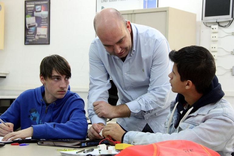 Un dels professors del programa de formació professional, conversant amb dos alumnes durant una sessió pràctica d&#039;electricitat a l&#039;Institut Comte de Rius de Tarragona.