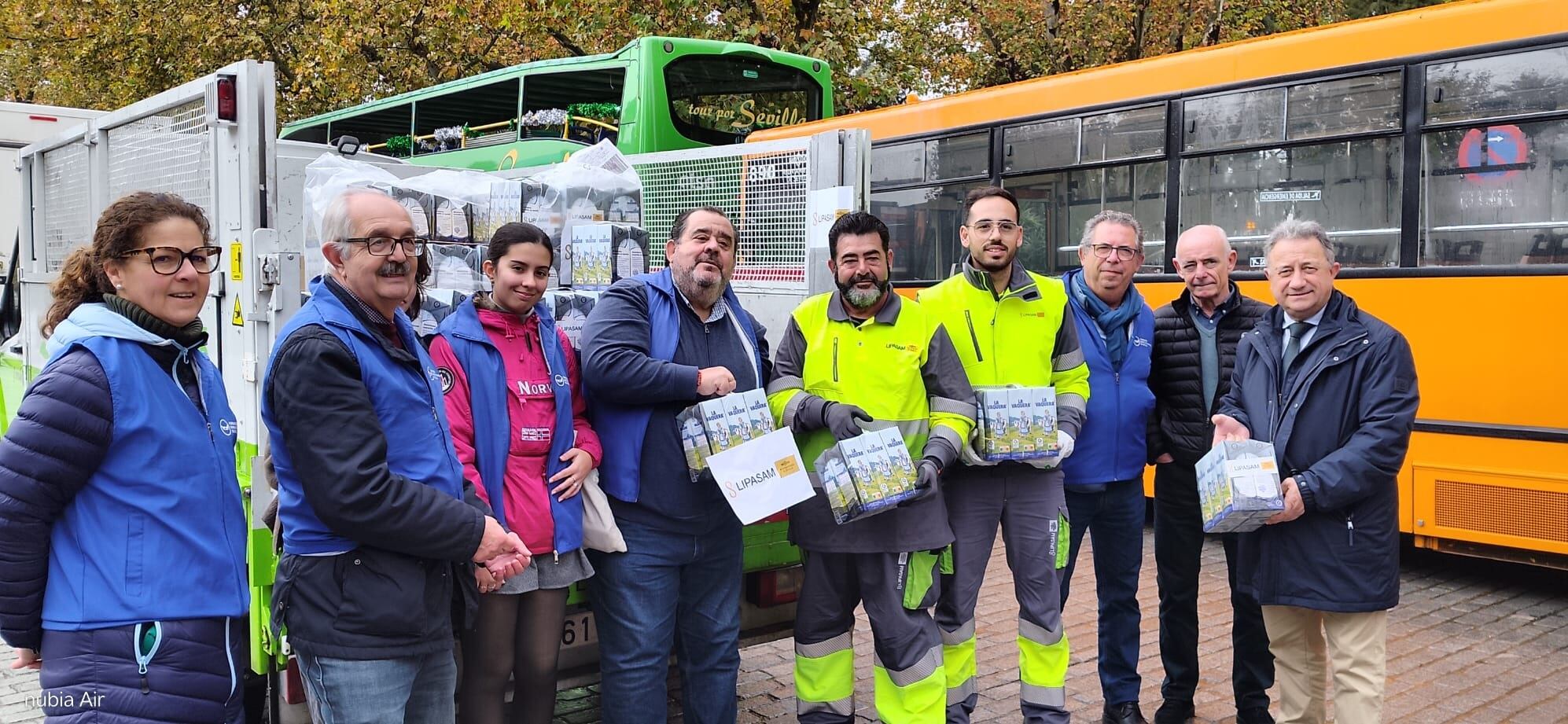 Voluntarios y Manuel Torreglosa, gerente de TUSSAM, en la entrega de los miles de litros de leche