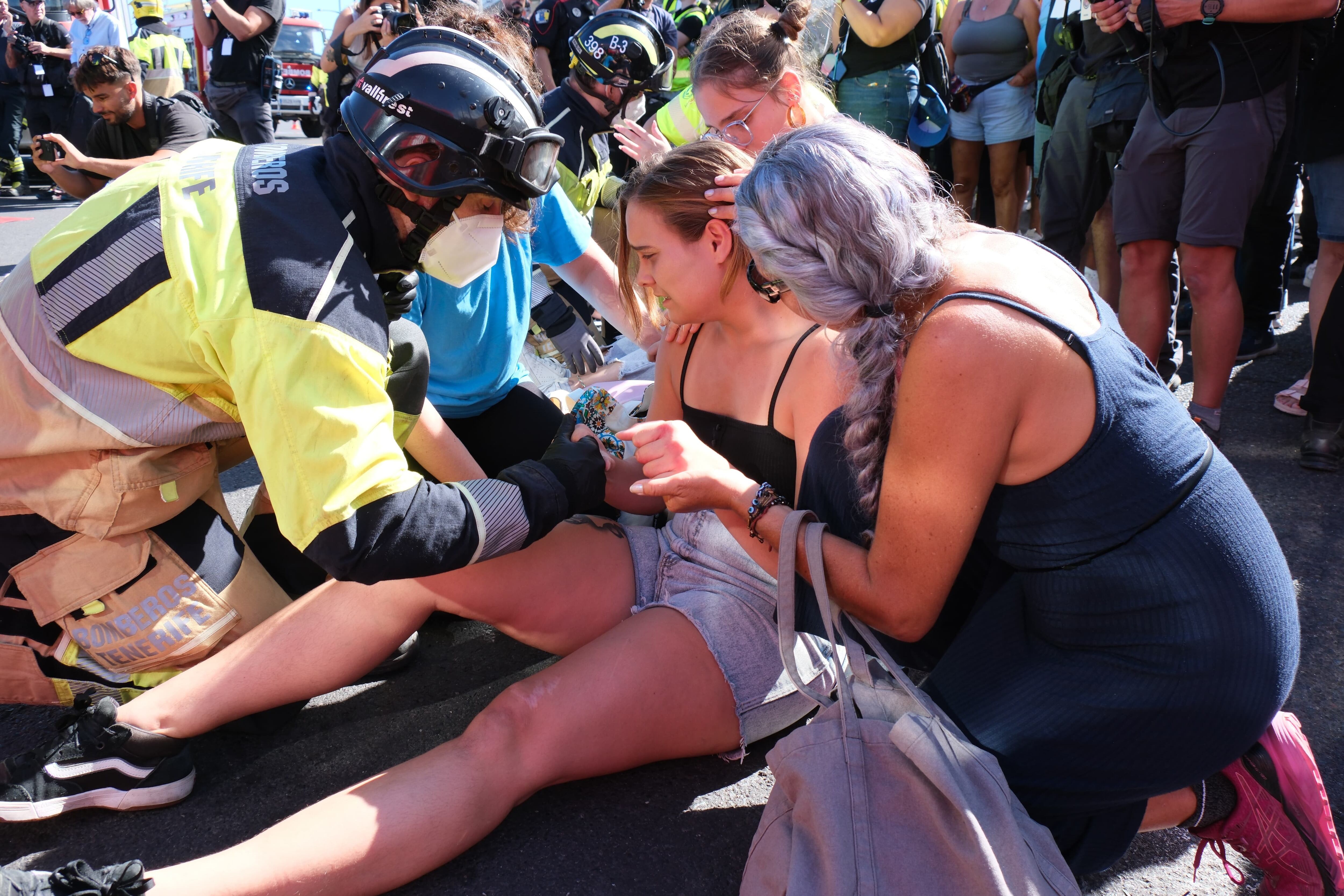 Un bombero simula que socorre a una chica durante el simulacro de erupción volcánica realizado en Garachico, en Tenerife, este viernes.