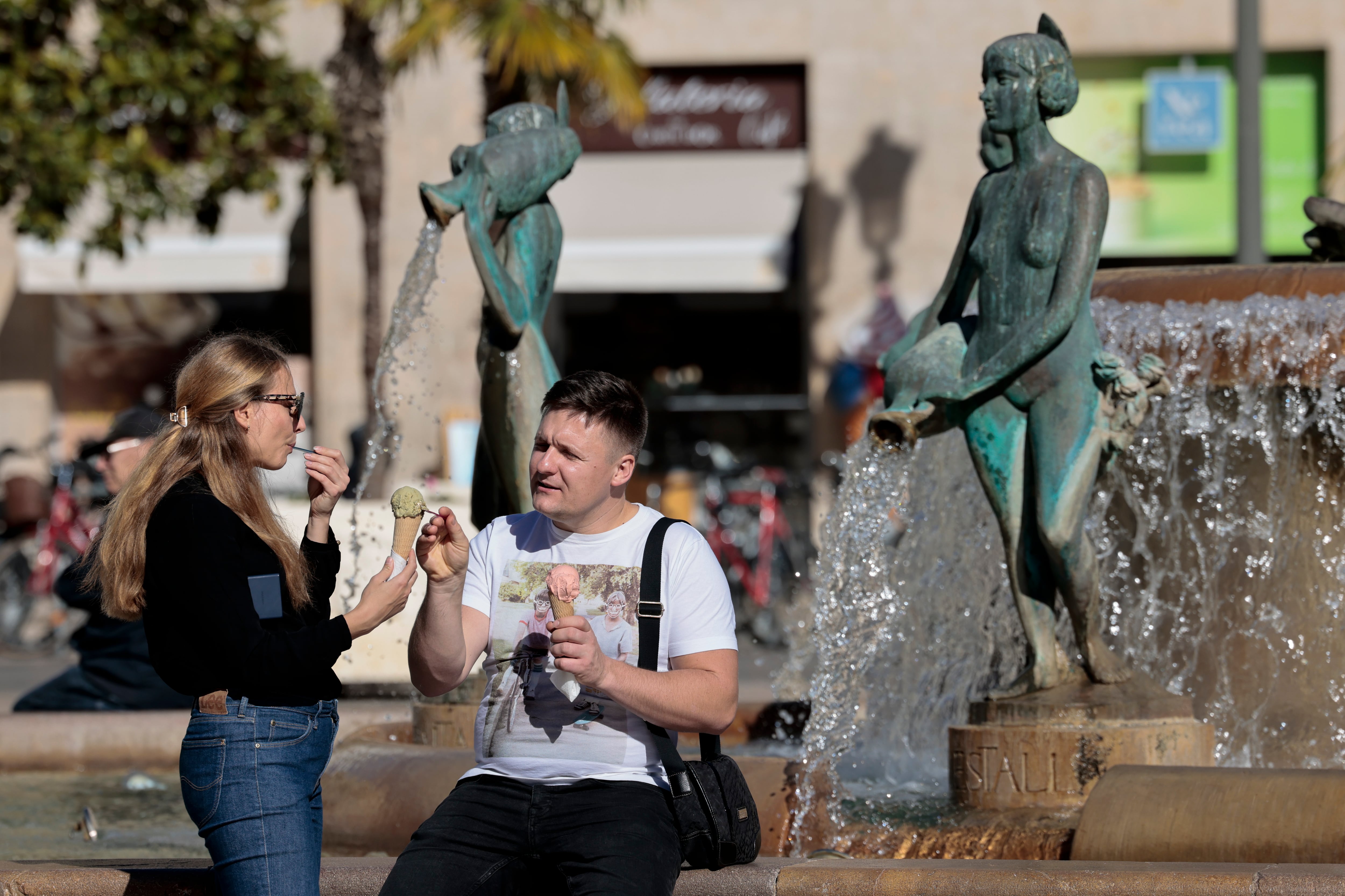 Dos personas disfrutan de un helado junto a una fuente en el mes de noviembre, cuando se alcanzaron máximas de hasta los 28 grados en Alicante y Castelló y 27 grados en València. EFE/Ana Escobar