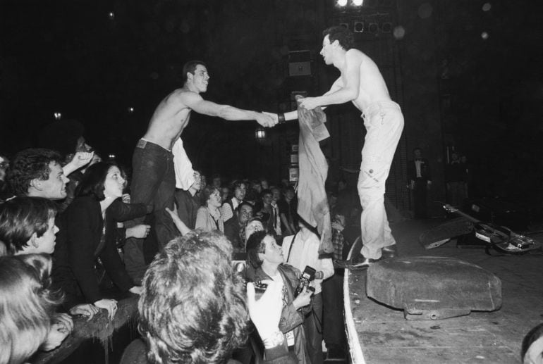 Joe Strummer (1952 - 2002), líder de The Clash, intercambia la camiseta con un seguidor en The Rainbow Theatre de Londres durante un concierto el 14 de mayo de 1977