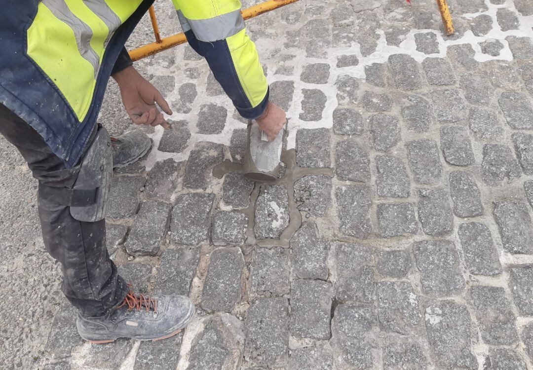 Un operario repone adoquines en una calle de la capital.