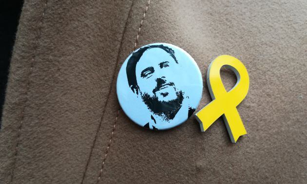 Chapa con la cara de Junqueras en la solapa del abrigo de Gabriel Rufián