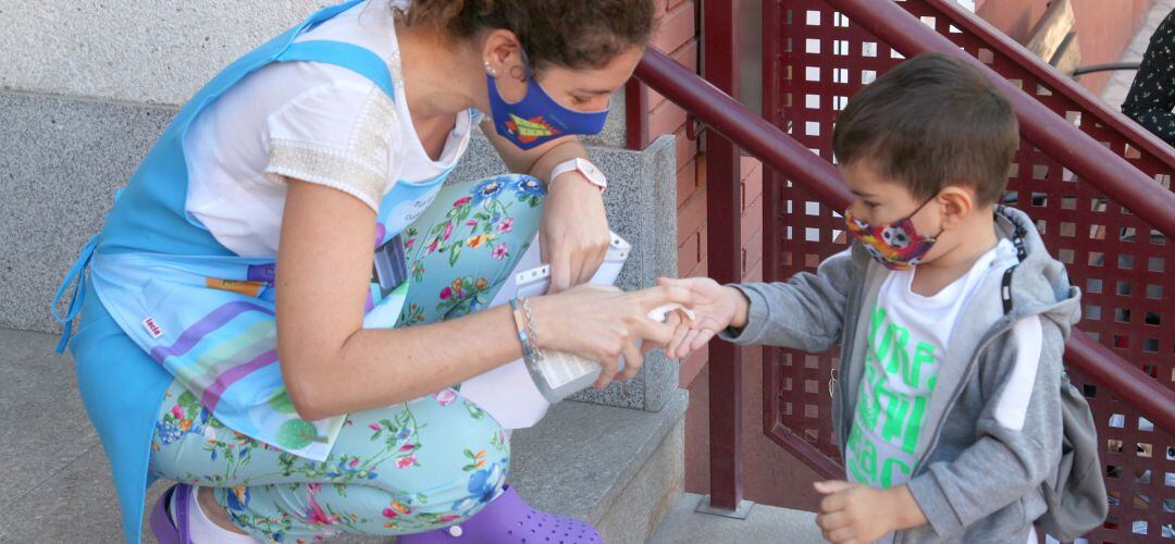 Menor echándose gel a la entrada de su colegio