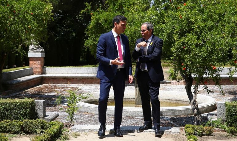 El presidente del Gobierno, Pedro Sánchez y el de la Generalitat, Quim Torra, durante un paseo por los jardines de la Moncloa