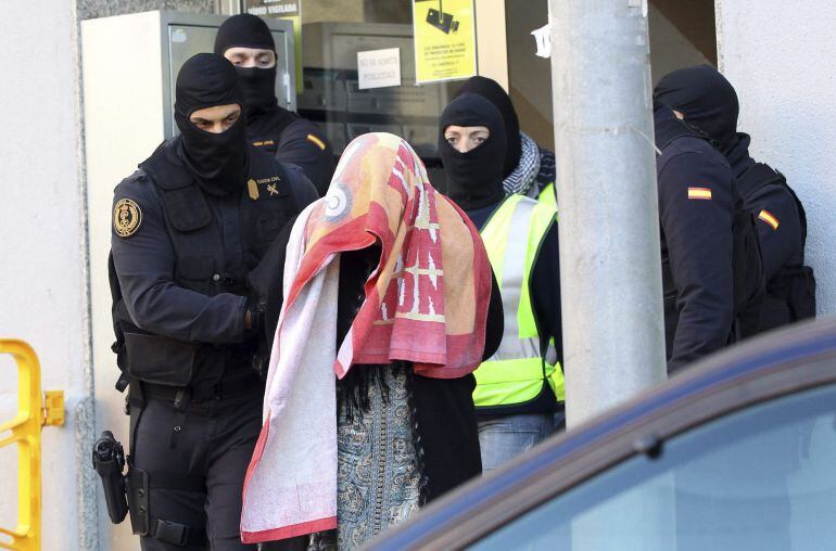 Agentes de la Guardia Civil escoltan a la mujer que, junto a su marido y a sus dos hijos gemelos, fueron detenidos este martes