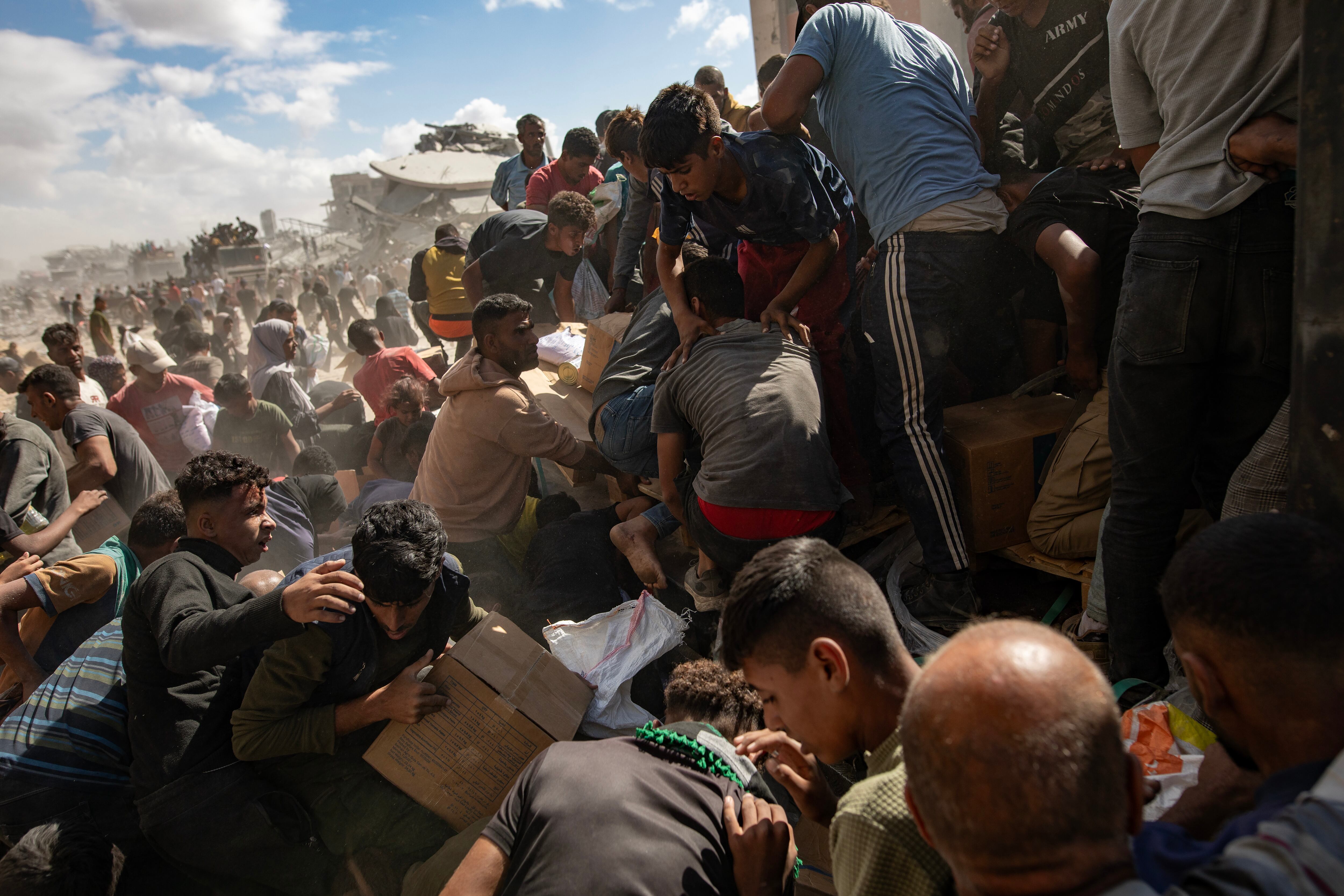 Los palestinos recogen ayuda de los camiones en Jan Yunis al sur de la Franja de Gaza.