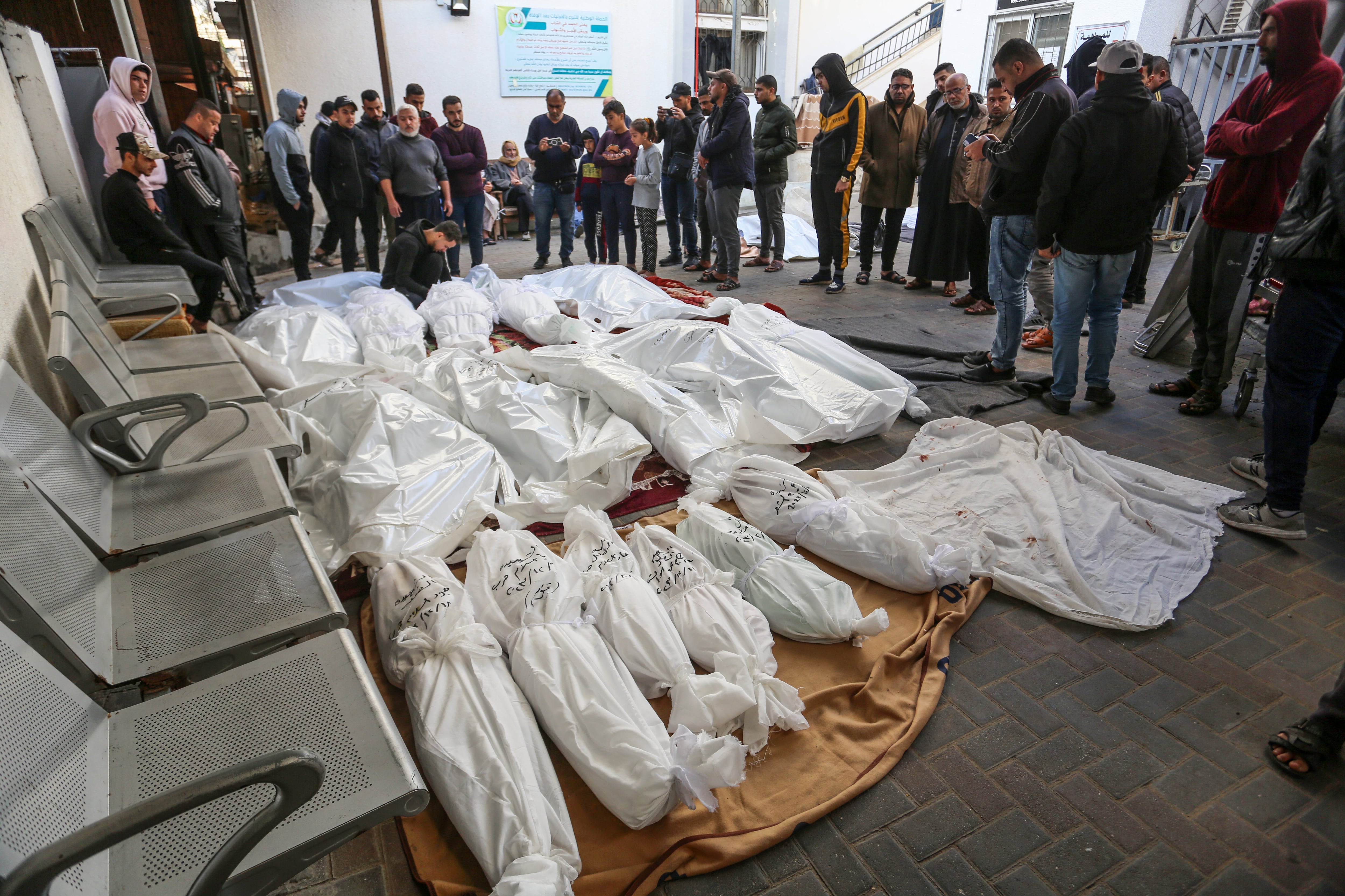 Familiares de palestinos fallecidos en los ataques de Israel junto a sus cuerpos en la morgue del hospital Al-Najar de Rafah, en Gaza