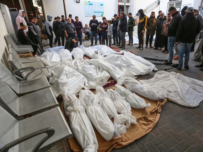 Familiares de palestinos fallecidos en los ataques de Israel junto a sus cuerpos en la morgue del hospital Al-Najar de Rafah, en Gaza