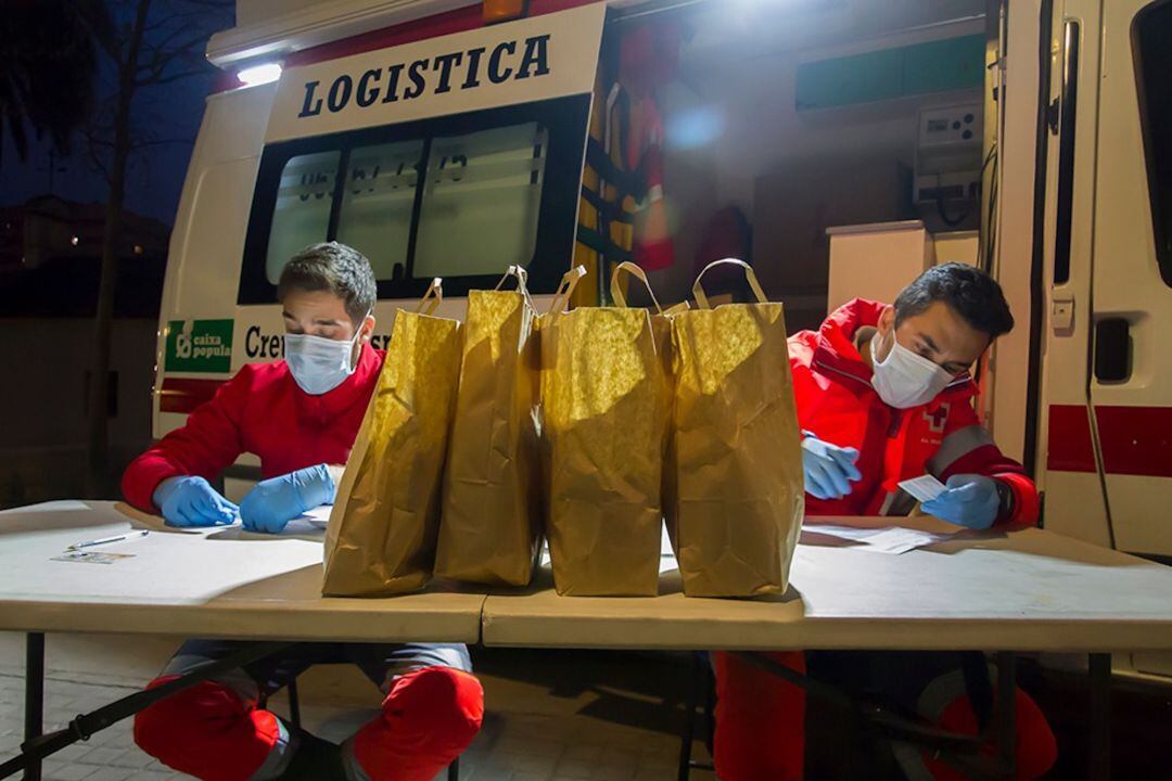 Los voluntarios re Cruz Roja reparten cada día kits de higiene y alimentación a las personas sin recursos en la ciudad de València