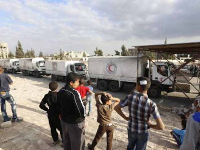 Varios camiones de la Media Luna Roja con ayuda humanitaria entran en el campo de refugiados del campo de refugiados de la ciudad de Douma, en el distrito de Damasco Siria