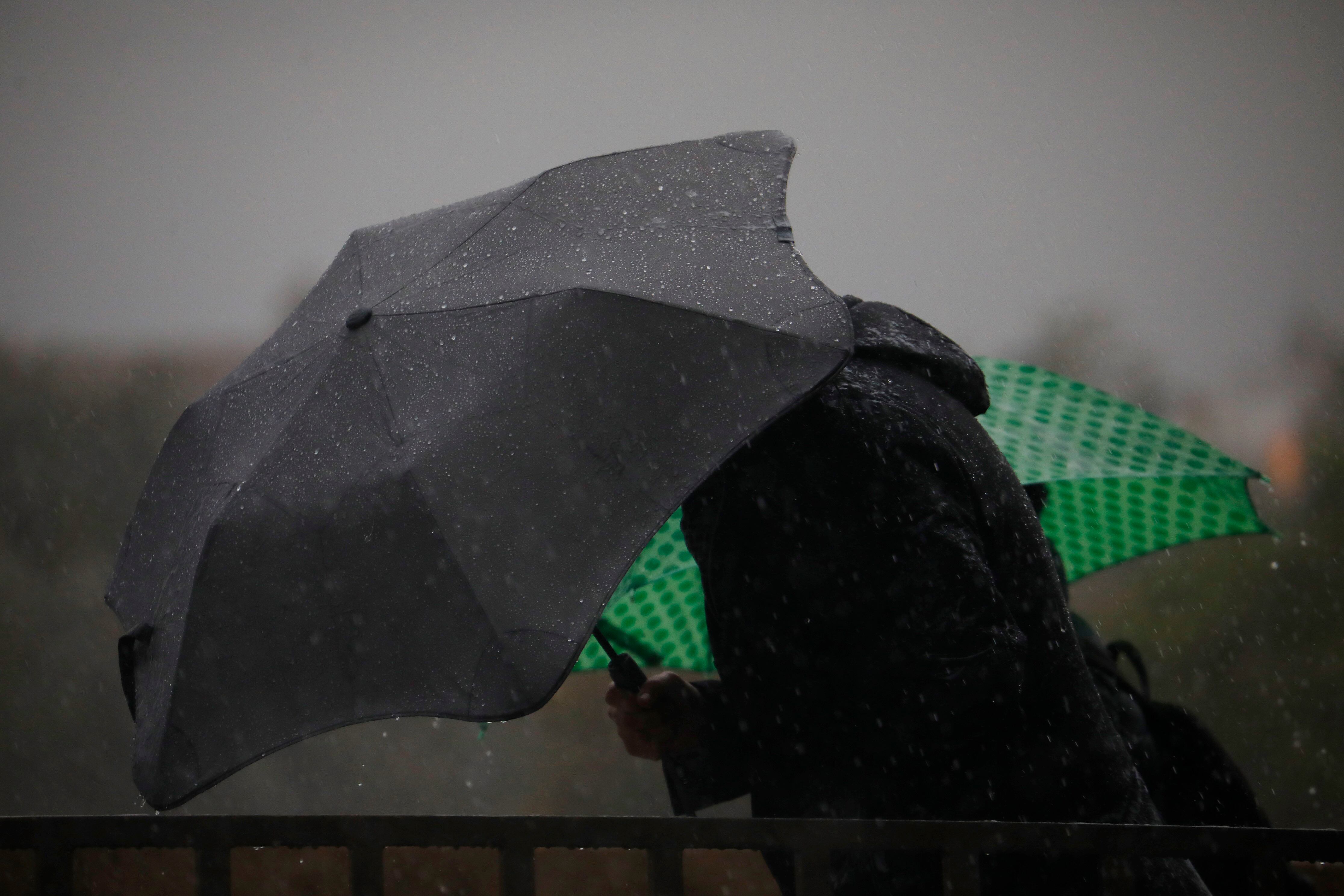 CÓRDOBA, 08/12/2022.- Variasp personas se protegen con un paraguas de la lluvia en una jornada en la que Córdoba se encuentra en aviso amarillo por lluvias. EFE/Salas
