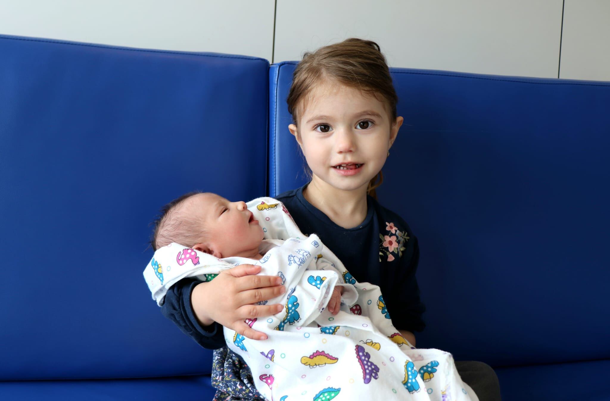 Enma de 3 años sosteniendo a su hermana Eva, la última bebé de 2025 de Ibiza