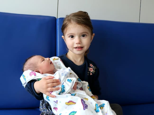 Enma de 3 años sosteniendo a su hermana Eva, la última bebé de 2025 de Ibiza