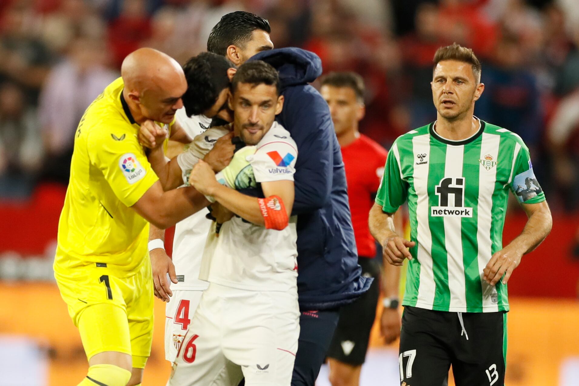 Jesús Navas, defensa del Sevilla, junto a su portero Marko Dmitrovic, y el centrocampista del Real Betis Joaquín tras recibir una patada durante el derbi. EFE/ José Manuel Vidal