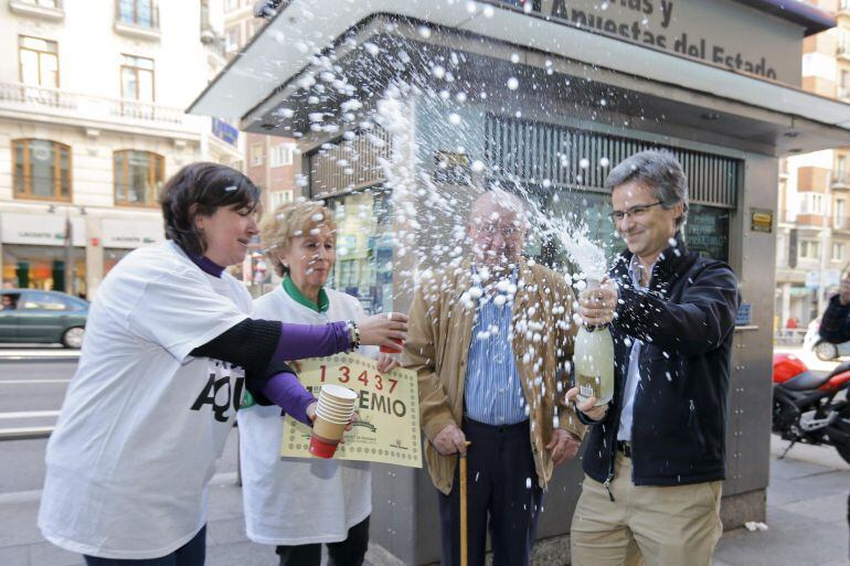 GRA279. MADRID, 22/12/2014.- Trabajadores de la administración de lotería nº 15 un kiosco situado frente al número 56 de la Gran Vía, celebran el primer premio del sorteo de Navidad, 13437, del que han vendido dos billetes. EFE/Juan Carlos Hidalgo