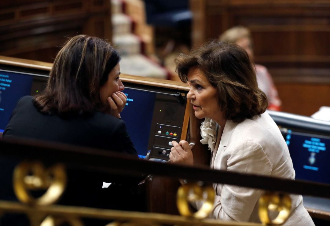 La vicepresidenta del Gobierno, Carmen Calvo (dcha), conversa con la diputada socialista Adriana Lastra, durante la segunda jornada del debate de investidura 